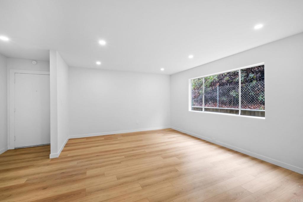 6775 Alvarado Road, Unit 26 San Diego, CA 92120 - Photo 6 of 24 a view of an empty room with wooden floor and a window