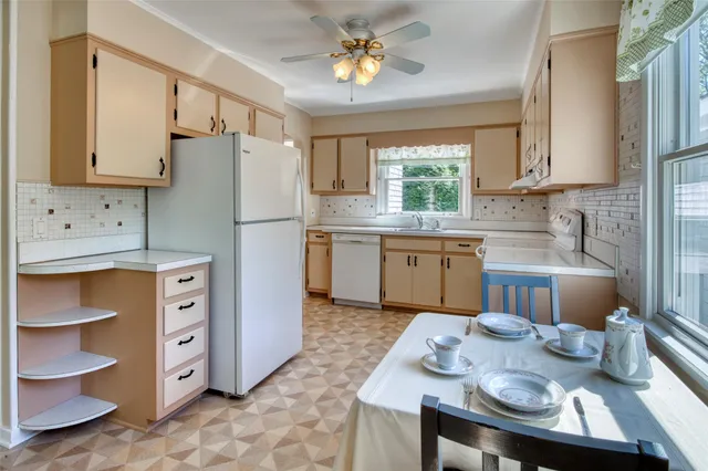 a kitchen with stainless steel appliances granite countertop a sink a stove a refrigerator cabinets and dining table