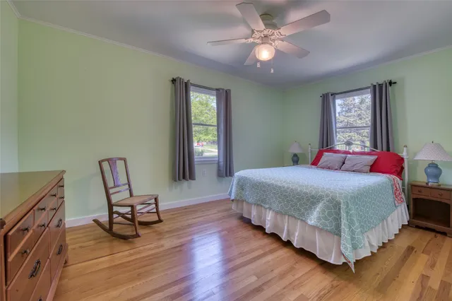 a bedroom with a bed a chair and a chandelier