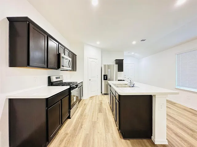 a kitchen with a sink stove and cabinets