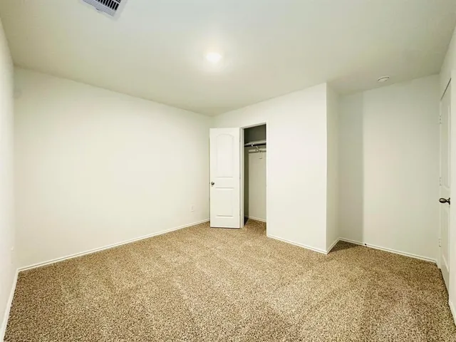 a view of an empty room and kitchen
