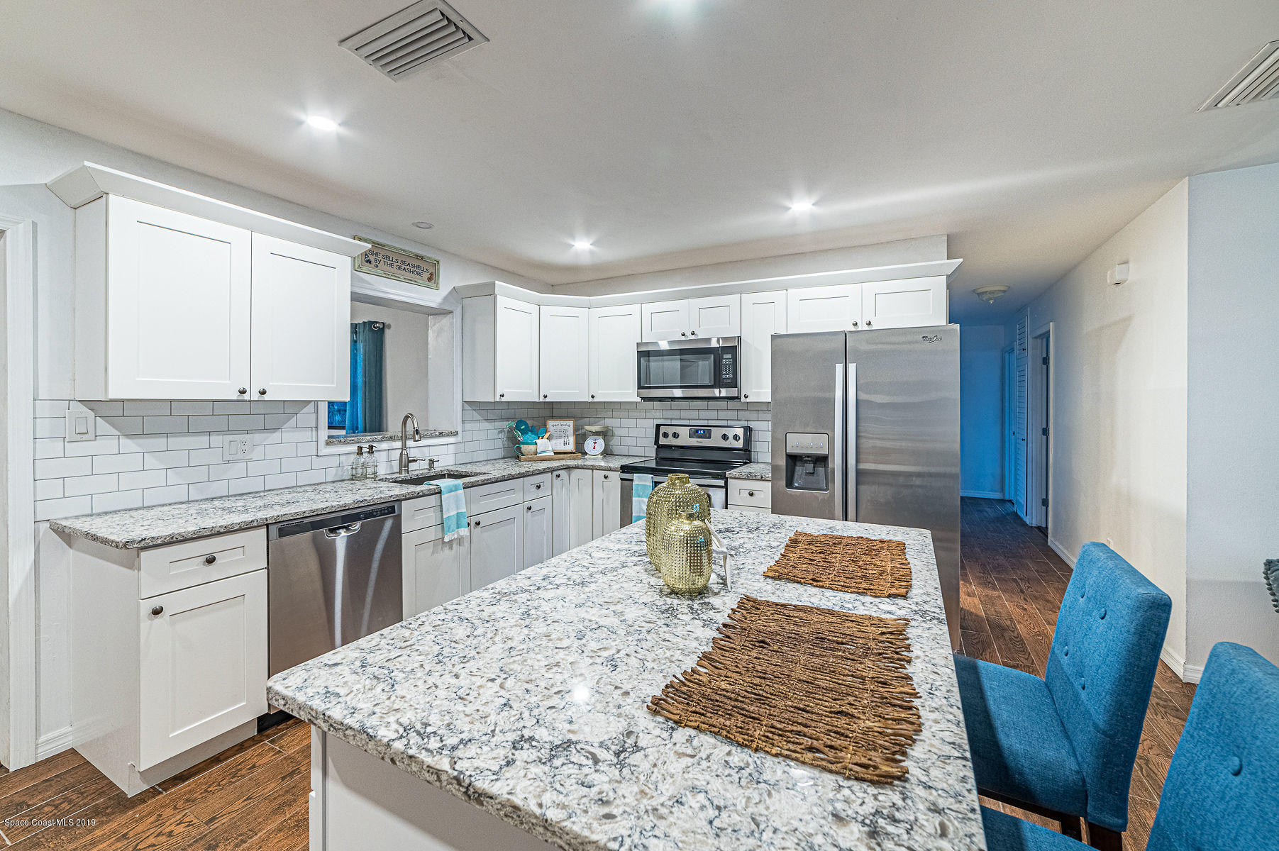 496 Seacrest Avenue Merritt Island, FL 32952 - Photo 12 of 33 a kitchen with stainless steel appliances granite countertop a table chairs sink refrigerator and cabinets
