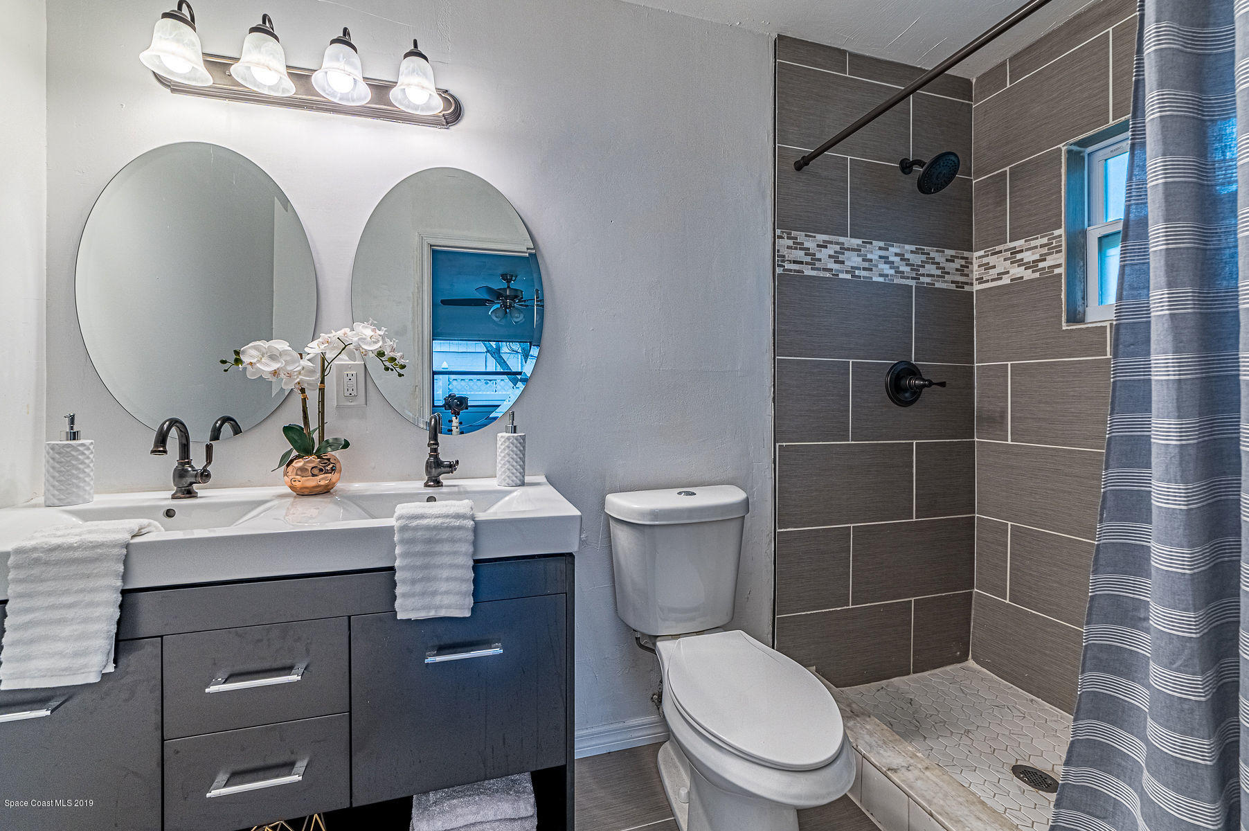 496 Seacrest Avenue Merritt Island, FL 32952 - Photo 31 of 33 a bathroom with a toilet sink and mirror