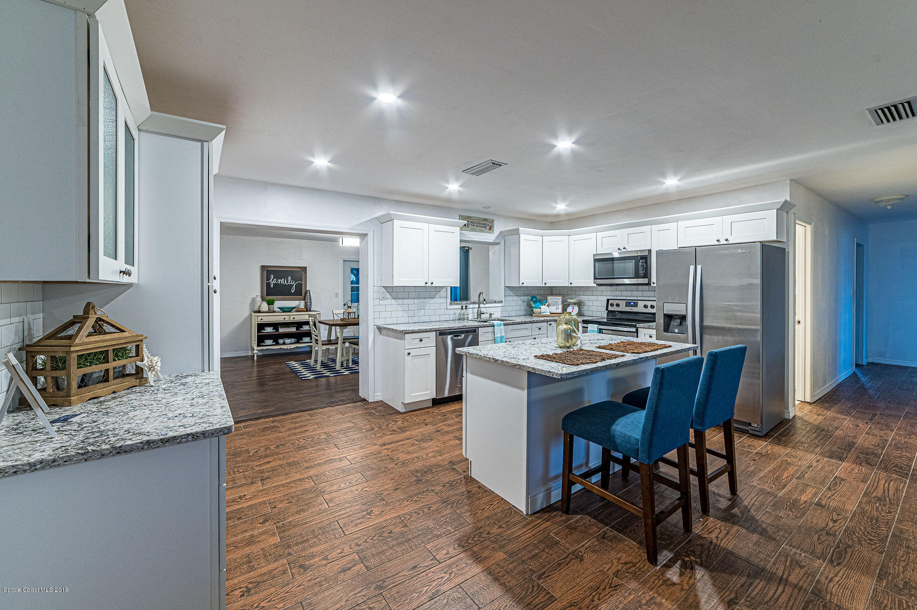 496 Seacrest Avenue Merritt Island, FL 32952 - Photo 8 of 33 a kitchen with stainless steel appliances granite countertop a table chairs sink refrigerator and cabinets
