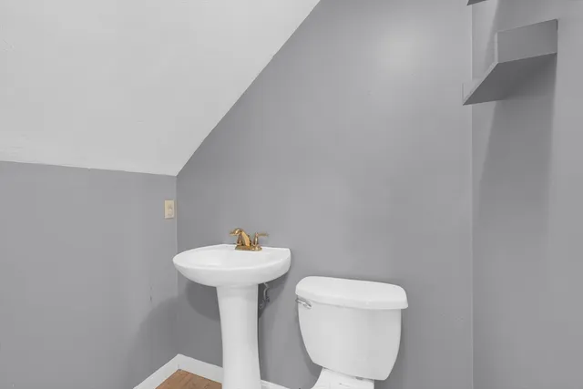 a bathroom with a toilet sink and mirror