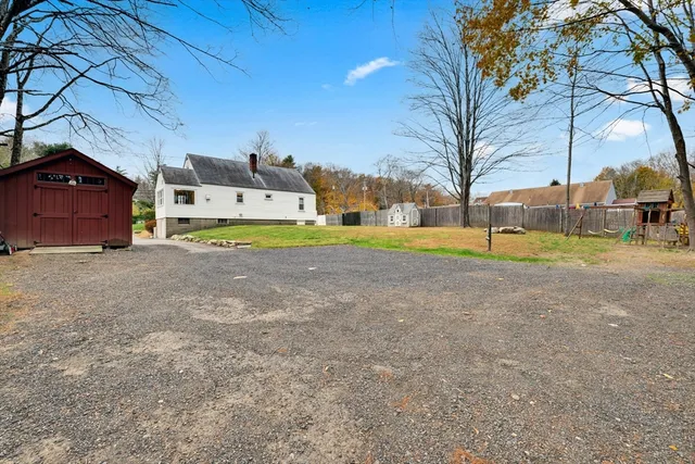 a view of a house with a yard and sitting area