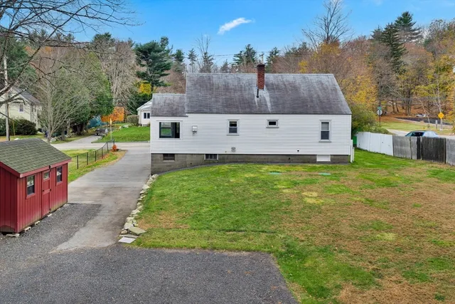 a view of a house with backyard and a tree
