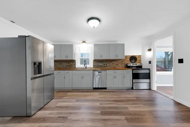 a kitchen with granite countertop a refrigerator and a stove top oven