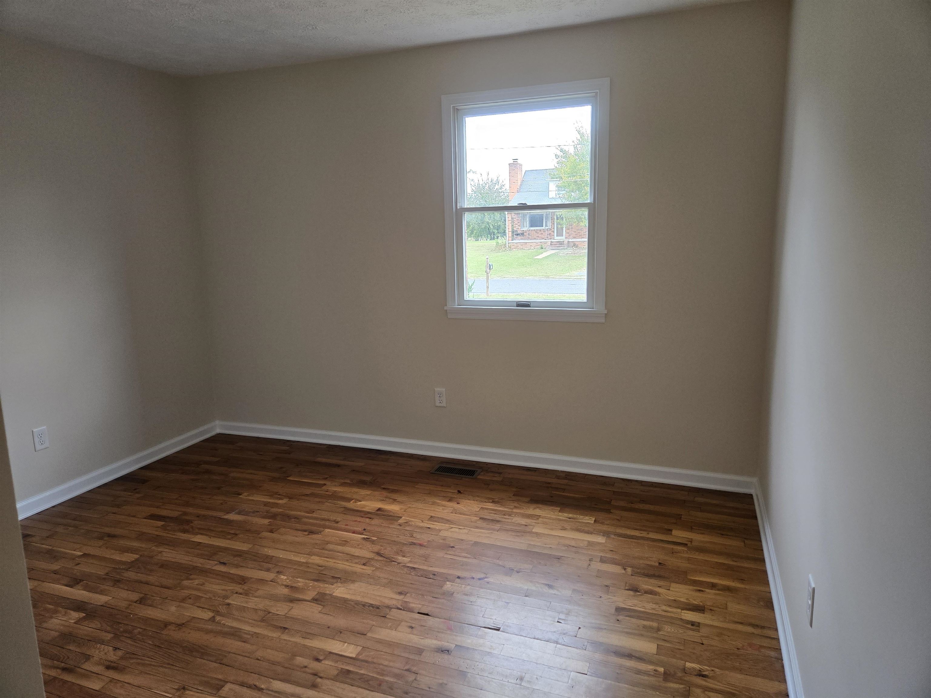 307 West Spring Avenue Elkton, VA 22827 - Photo 15 of 28 a view of an empty room with wooden floor and a window