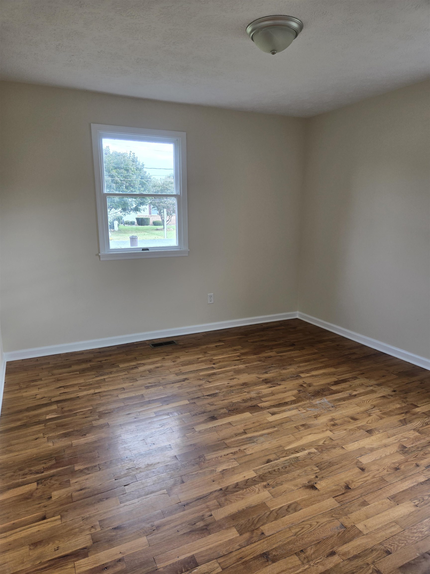 307 West Spring Avenue Elkton, VA 22827 - Photo 16 of 28 an empty room with wooden floor and windows