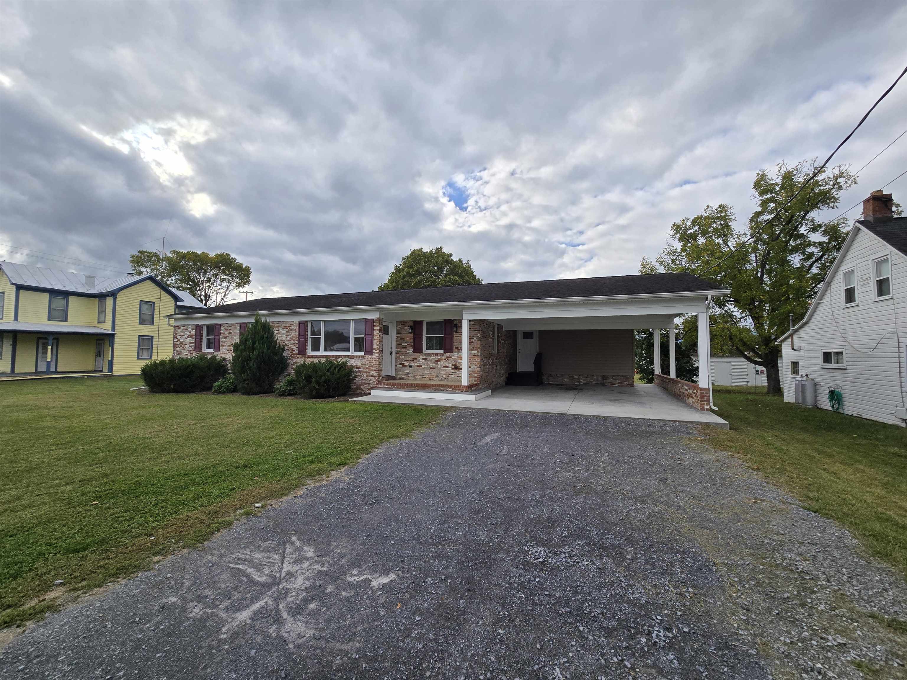 307 West Spring Avenue Elkton, VA 22827 - Photo 2 of 28 a front view of a house with a garden and trees