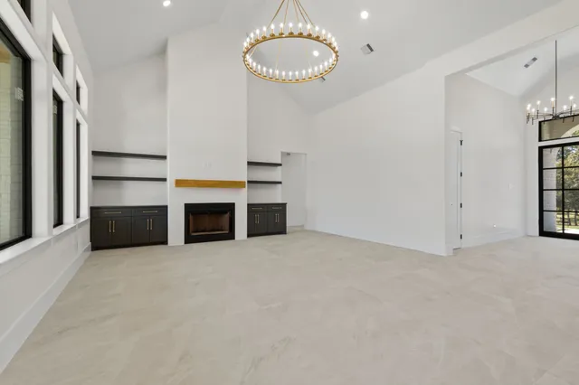 an empty room with fireplace and windows