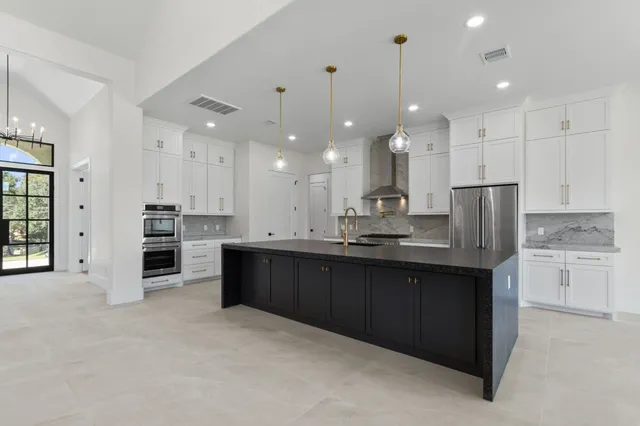 a large kitchen with kitchen island granite countertop a large counter top stainless steel appliances and cabinets