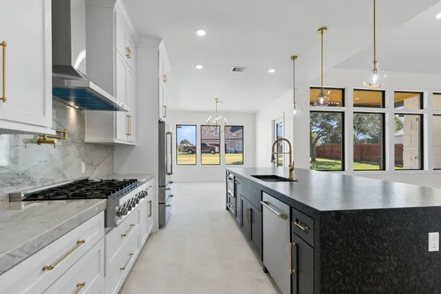 a kitchen with stainless steel appliances granite countertop a stove and a sink