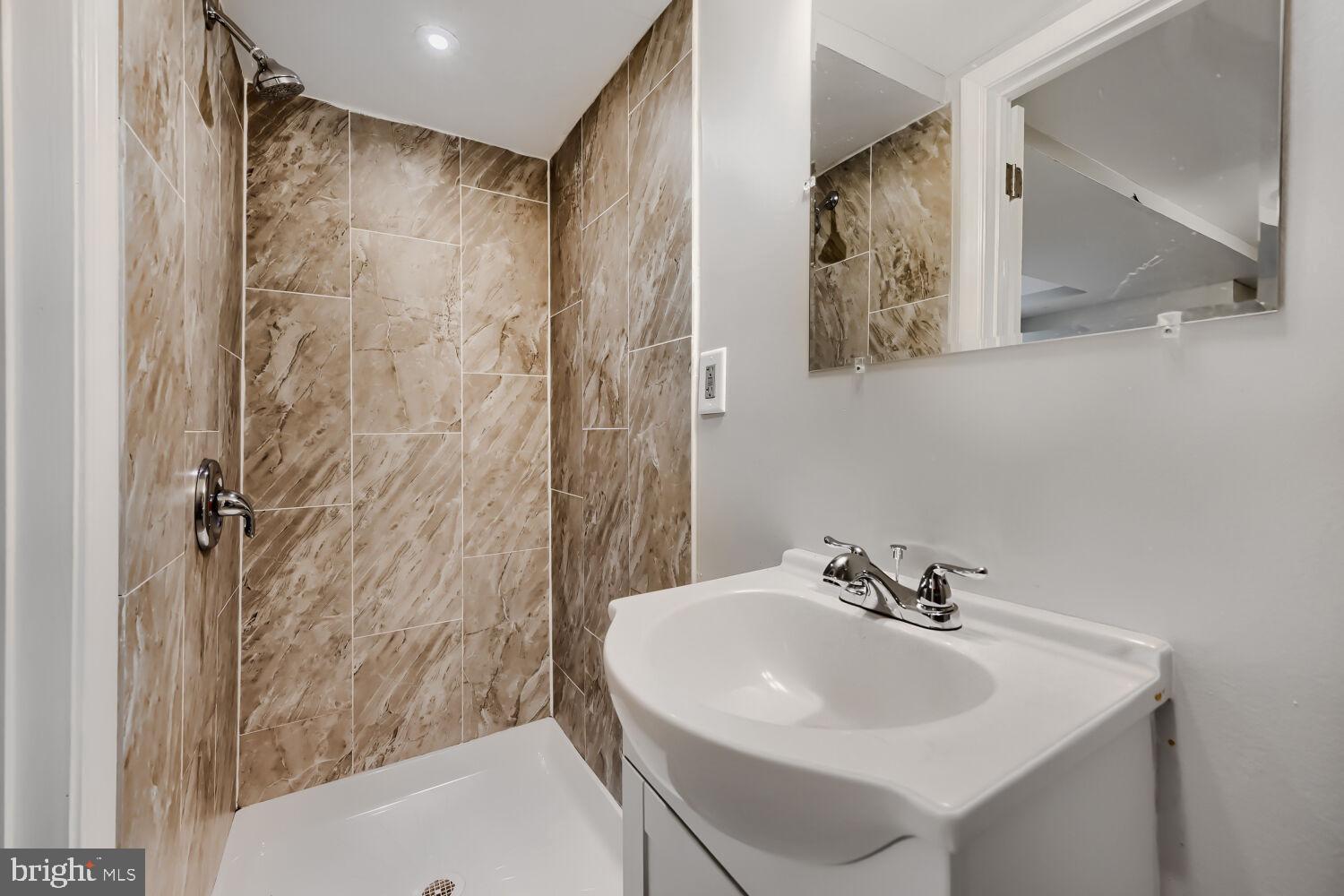 1014 Lyndhurst Street Baltimore, MD 21229 - Photo 25 of 29 a bathroom with a sink a shower and a mirror