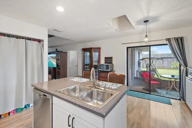 a kitchen view with granite countertop a sink and refrigerator