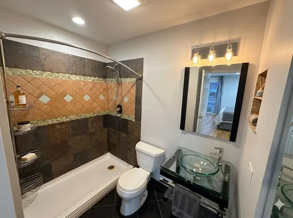 a bathroom with a toilet a sink and mirror