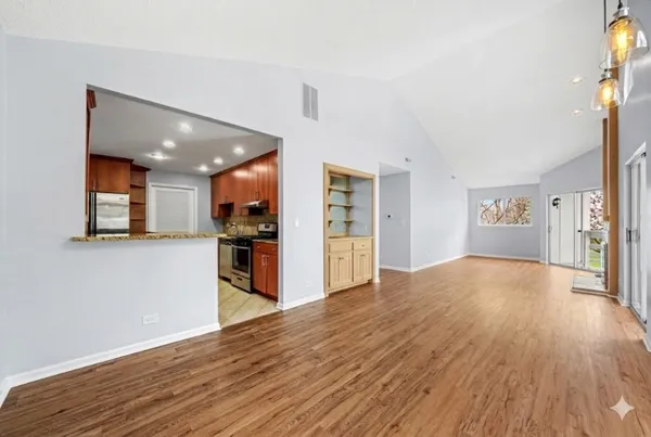 a view of a kitchen with refrigerator and wooden floor