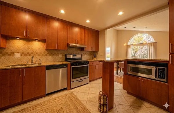 a kitchen with stainless steel appliances kitchen island granite countertop a stove a sink and a microwave