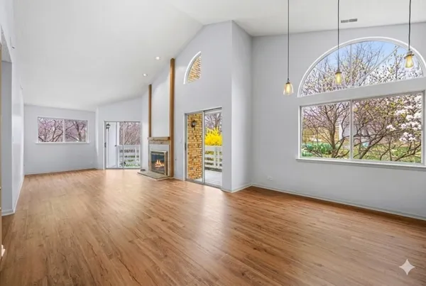 an empty room with windows and wooden floor