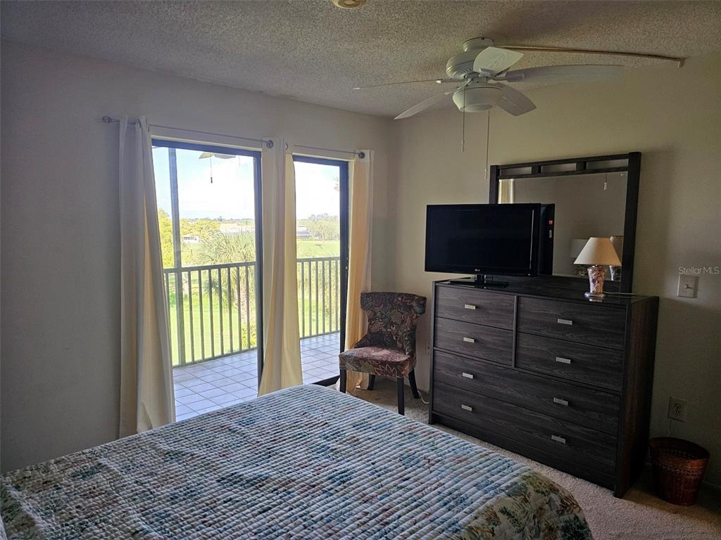 4119 61st Ave Terrace West, Unit 404 Bradenton, FL 34210 - Photo 16 of 22 a bedroom with a bed and a flat screen tv
