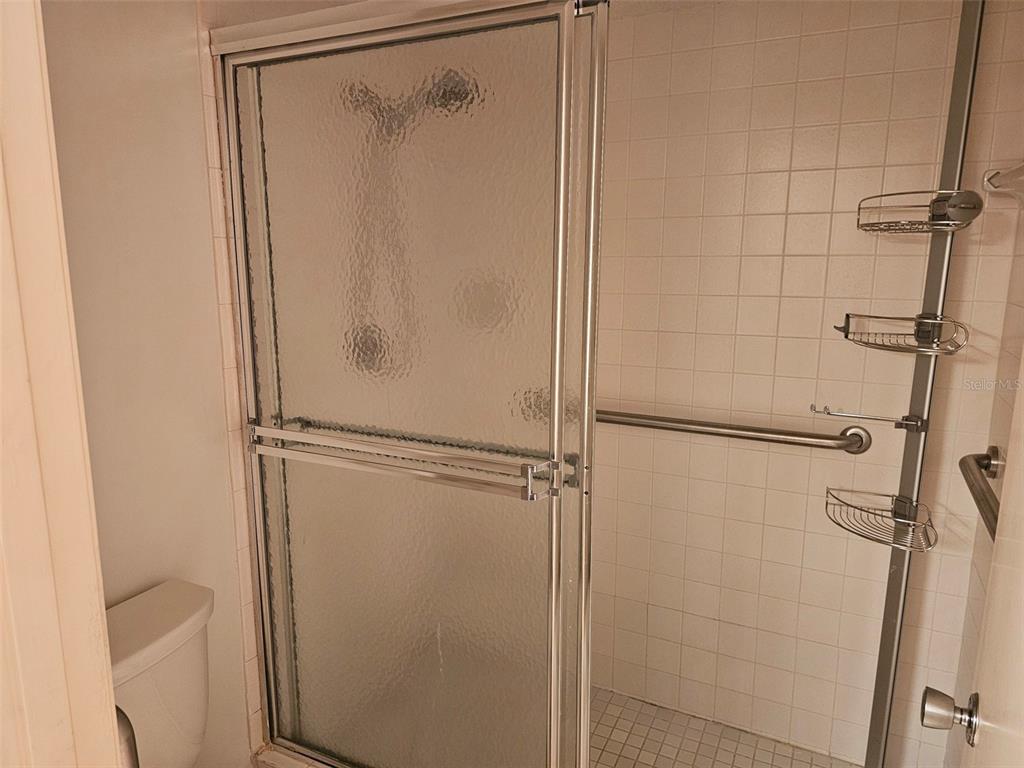 4119 61st Ave Terrace West, Unit 404 Bradenton, FL 34210 - Photo 18 of 22 a bathroom with a glass shower door