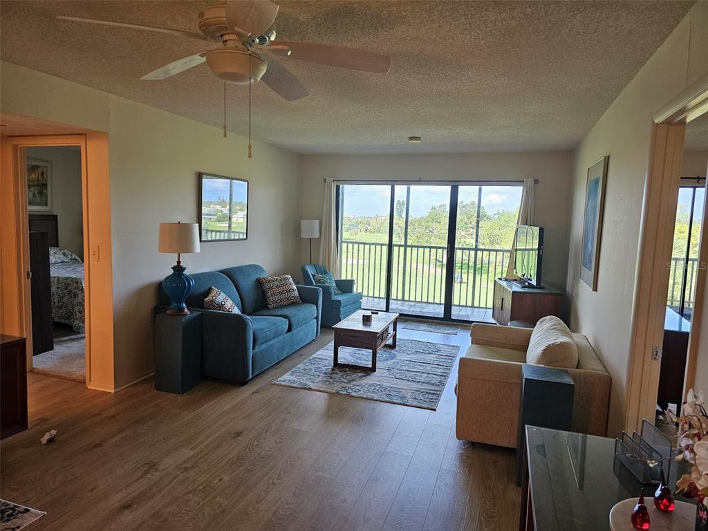 4119 61st Ave Terrace West, Unit 404 Bradenton, FL 34210 - Photo 2 of 22 a living room with furniture and a large window