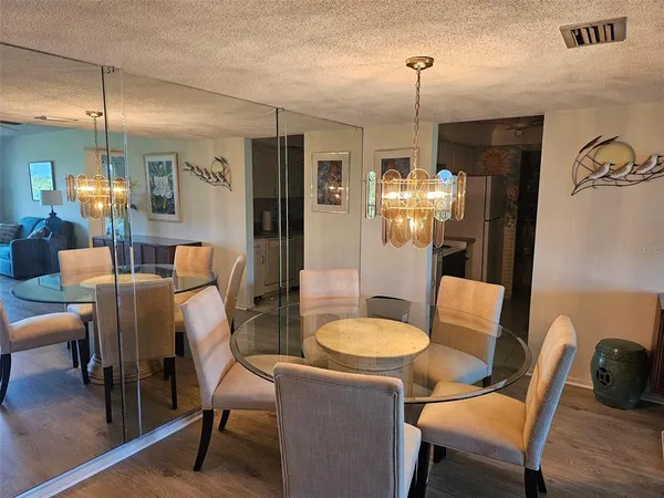 a dining room with furniture a chandelier and wooden floor