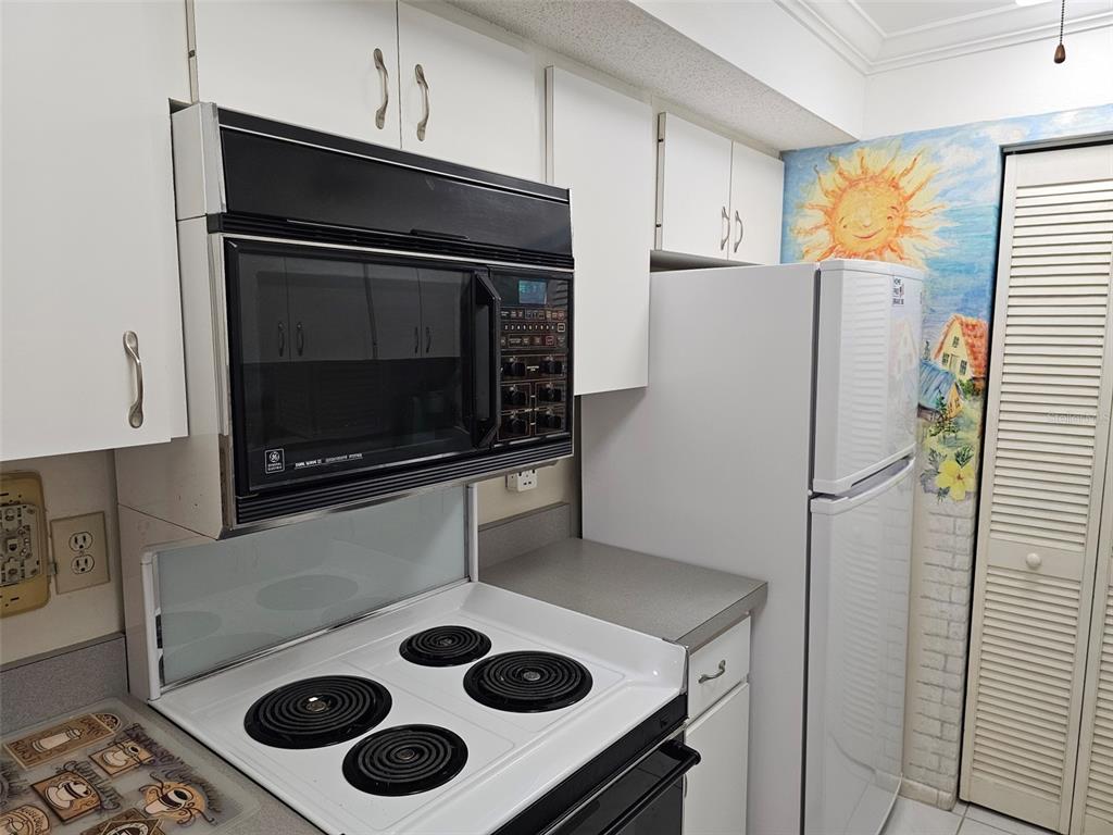 4119 61st Ave Terrace West, Unit 404 Bradenton, FL 34210 - Photo 4 of 22 a kitchen with a refrigerator stove and microwave