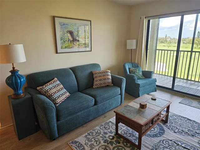 a living room with furniture and a window with balcony view