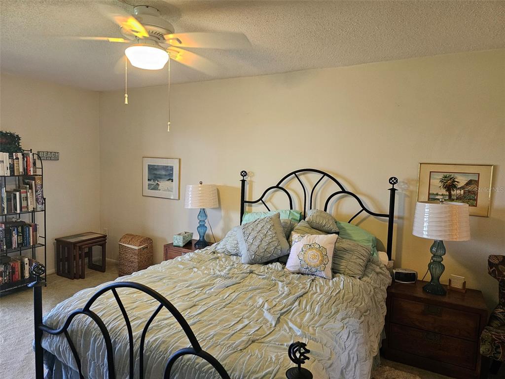 4119 61st Ave Terrace West, Unit 404 Bradenton, FL 34210 - Photo 9 of 22 a bedroom with bed and a chandelier