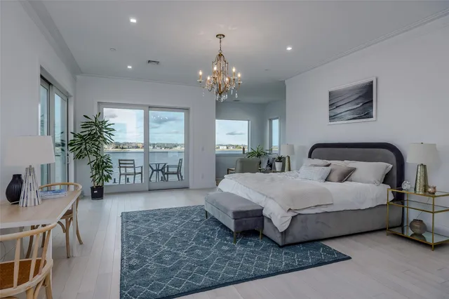 a spacious bedroom with a bed and a chandelier