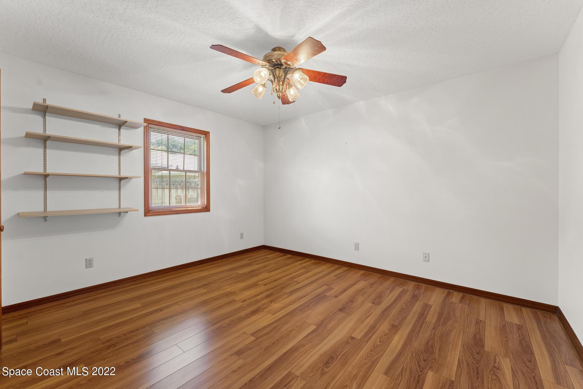 588 Peregrine Drive Indialantic, FL 32903 - Photo 14 of 23 an empty room with wooden floor fan and windows