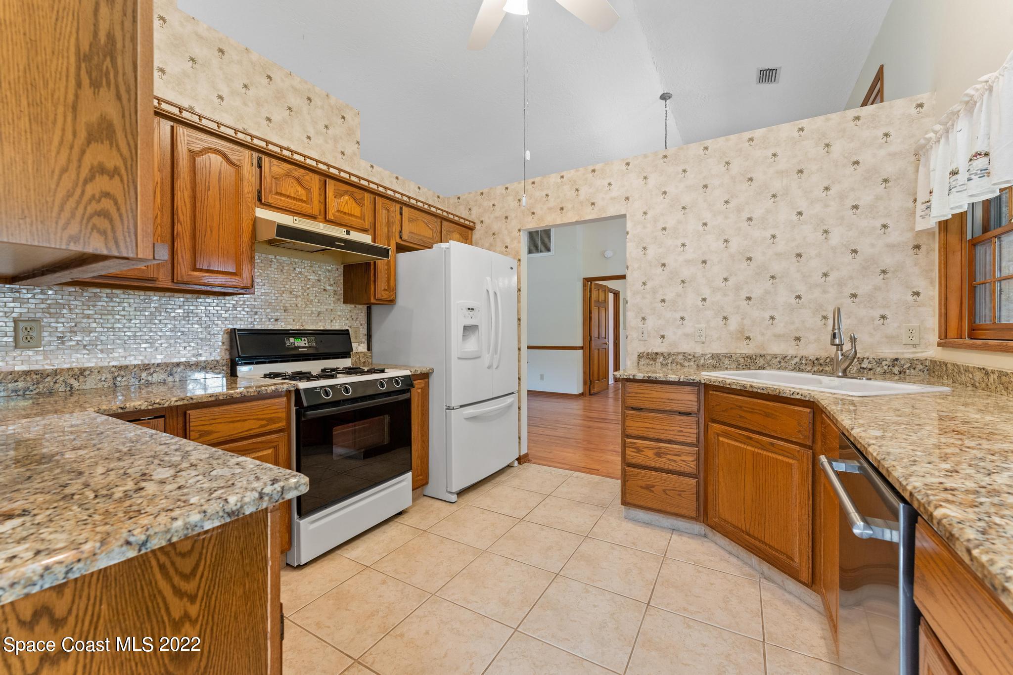 588 Peregrine Drive Indialantic, FL 32903 - Photo 3 of 23 a kitchen with stainless steel appliances granite countertop a sink stove and refrigerator