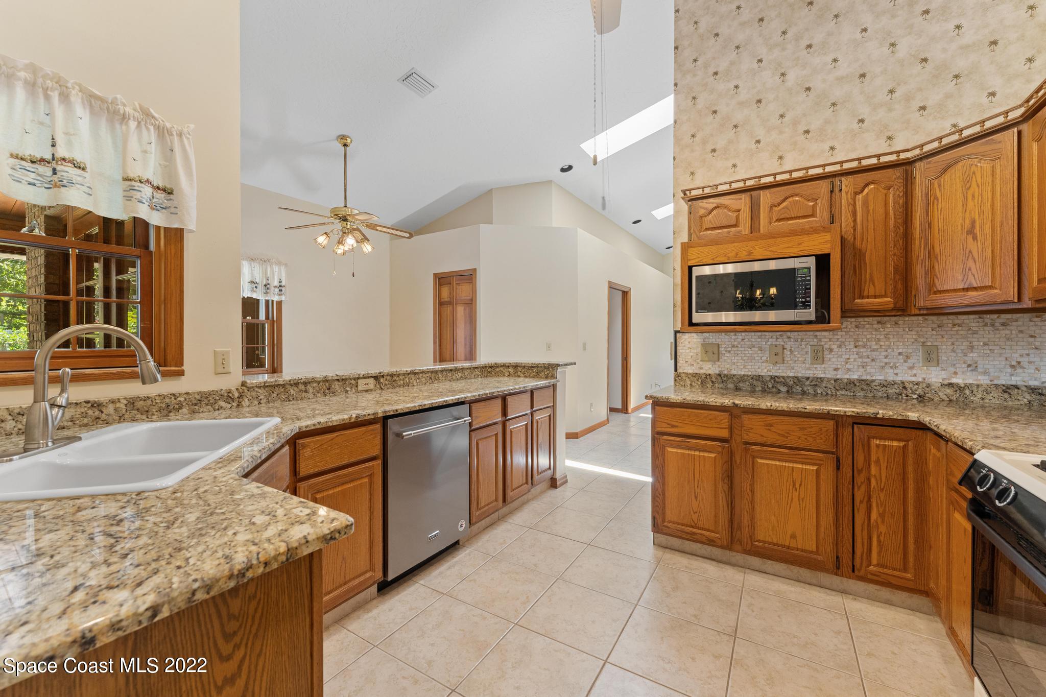 588 Peregrine Drive Indialantic, FL 32903 - Photo 5 of 23 a kitchen with stainless steel appliances granite countertop a sink and a stove
