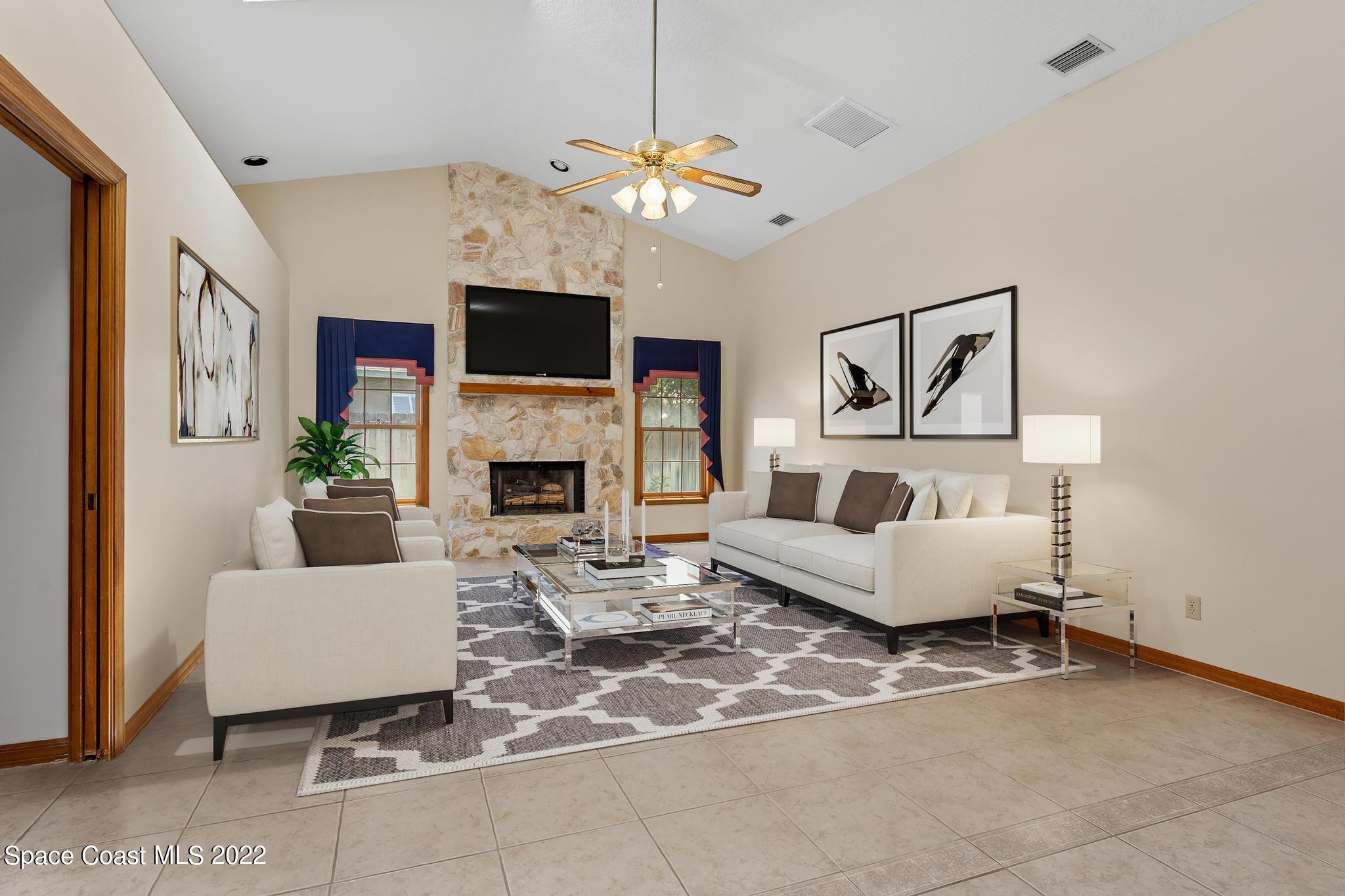 588 Peregrine Drive Indialantic, FL 32903 - Photo 7 of 23 a living room with furniture a flat screen tv and a fireplace