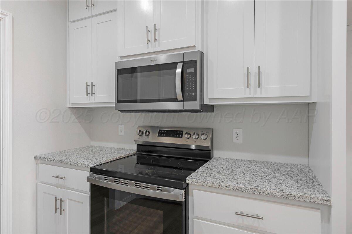 4204 Beacon Road Amarillo, TX 79118 - Photo 9 of 19 a kitchen with granite countertop white cabinets and a stove top oven