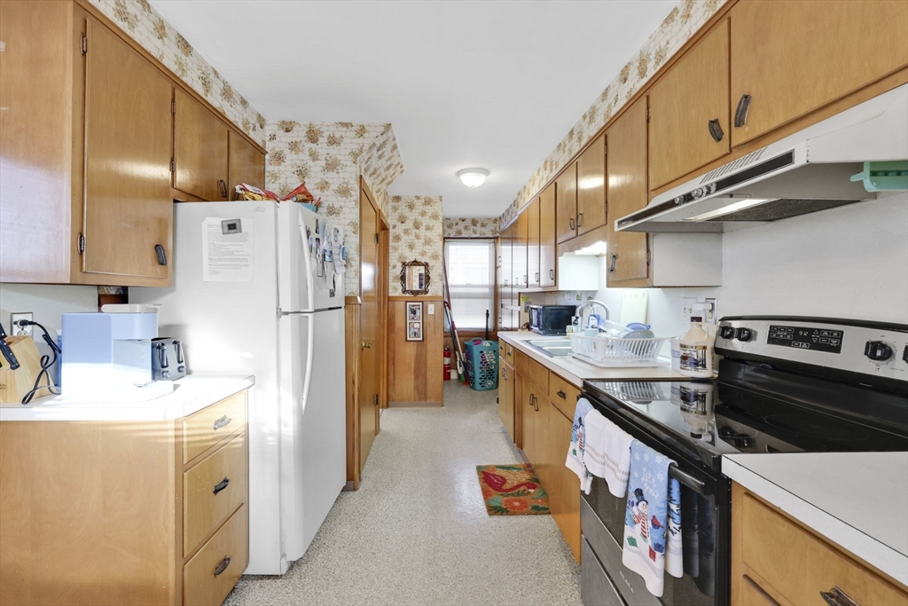 59 Prospect Street Ludlow, MA 01056 - Photo 11 of 42 a kitchen with a sink a refrigerator and a stove top oven