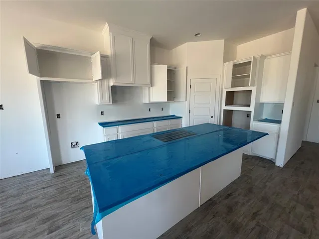 a living room with stainless steel appliances kitchen island granite countertop wooden cabinets and sink