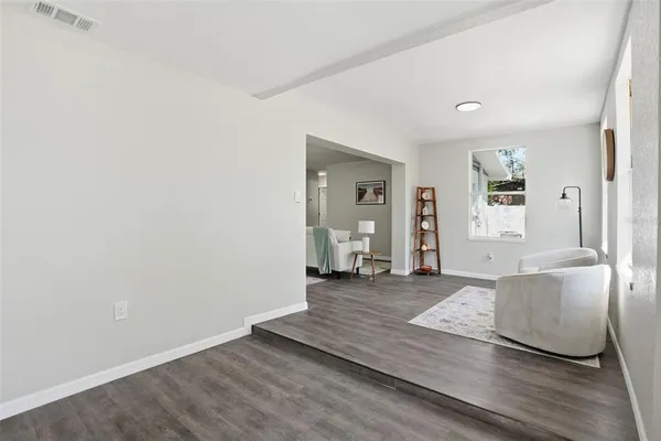 a view of a livingroom with wooden floor and furniture