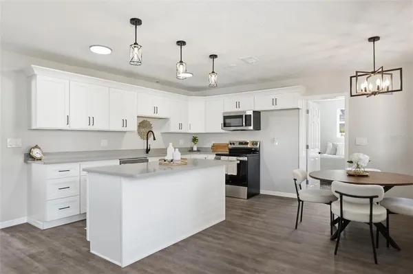 a kitchen with kitchen island granite countertop a sink cabinets and wooden floor