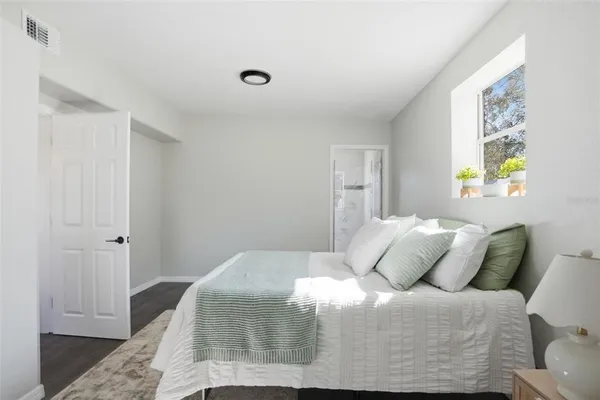 a bedroom with a bed and painting on the wall