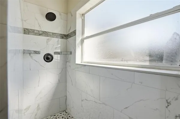 a bathroom with a window and a shower