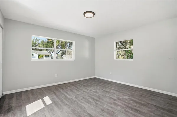 an empty room with wooden floor and window