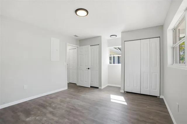 an empty room with windows and closet