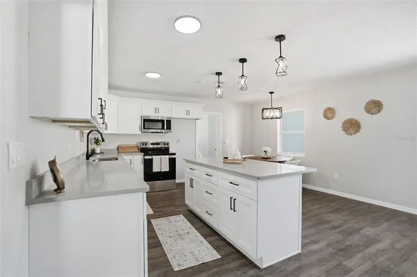a kitchen with granite countertop a sink stove and cabinets