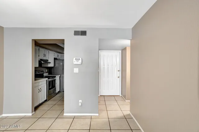 a kitchen with stainless steel appliances granite countertop a stove a refrigerator and a white cabinets