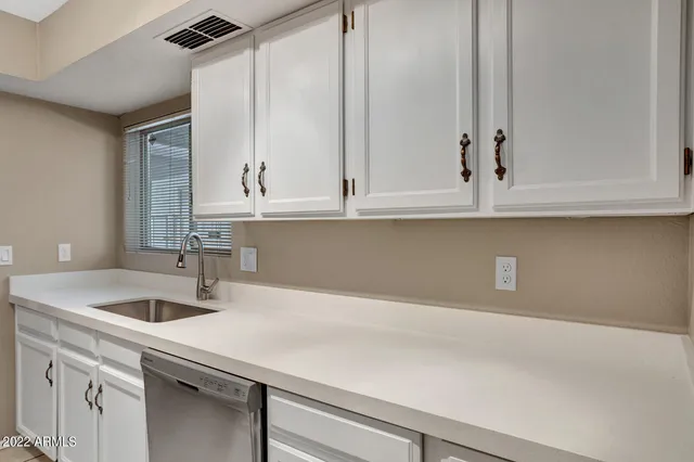 a kitchen with a sink cabinets and window