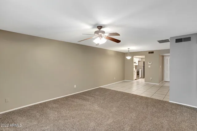 a view of a room with a ceiling fan and window