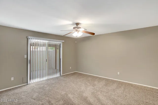a view of an empty room with a chandelier fan